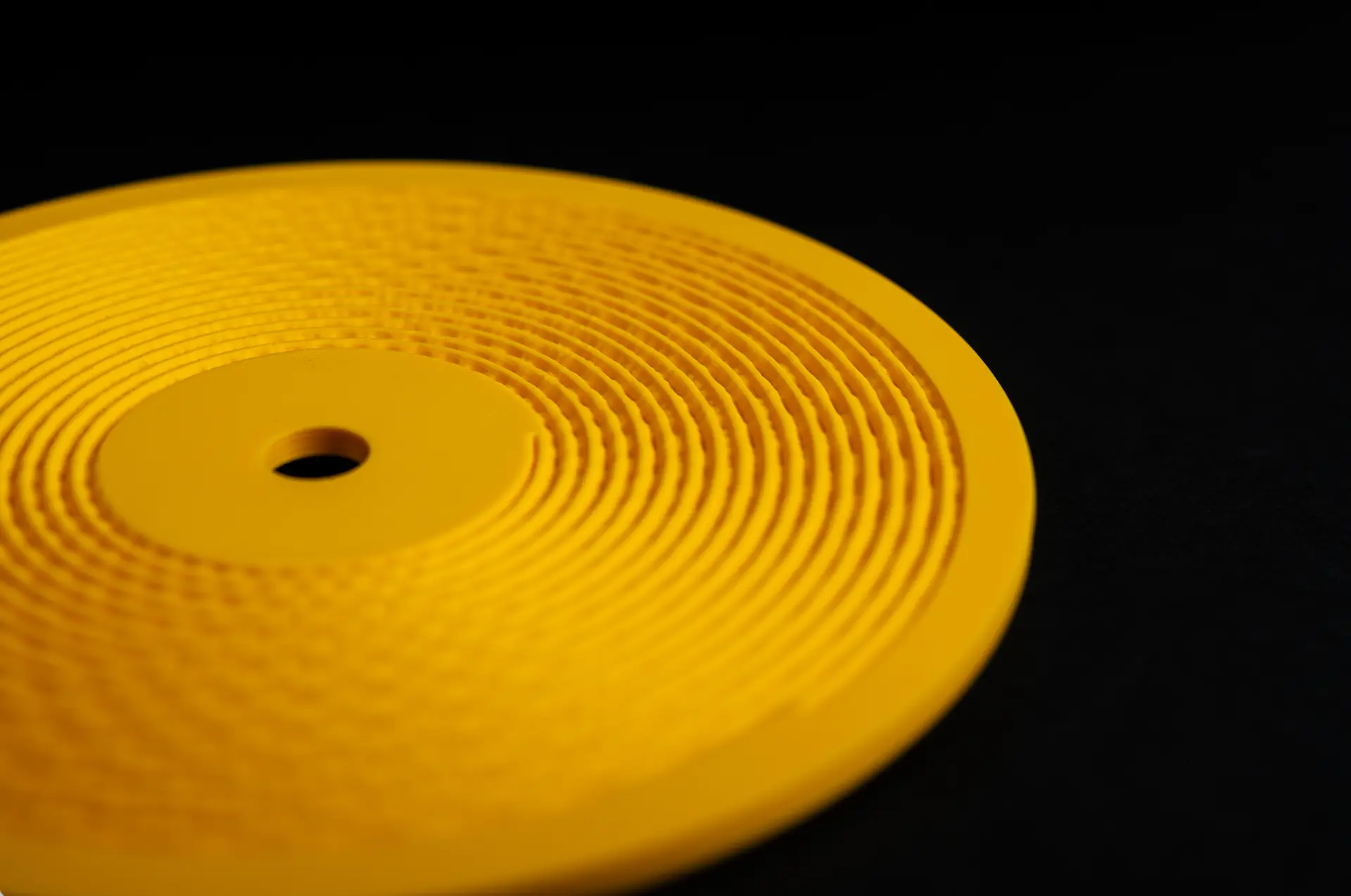 A listener wearing headphones holds a gold Kräftsound disc against the city lights at night